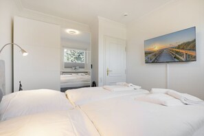 A hotel room with two beds, a large window, a painting of a bridge, and a mirror. - An der Seedüne, App. Carpe diem - "Relax in our vacation apartment at (Unknown)