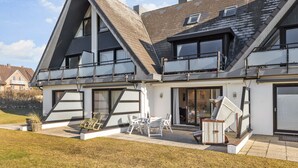 A modern two-story house with a sloped roof, large windows, and a balcony. - An der Seedüne, App. Carpe diem - "Relax in our vacation apartment at (Unknown)