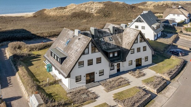 A modern two-story house with a sloped roof, large windows, and a view of the sea. - An der Seedüne, App. Carpe diem - "Relax in our vacation apartment at (Unknown)
