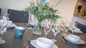 A dining table set with clear glassware, plates, and a blue mug. - An der Seedüne, App. Carpe diem - "Relax in our vacation apartment at (Unknown)