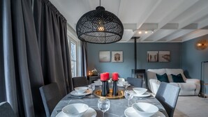 A dining area with a round table set for four, featuring white plates, bowls, and cutlery. - Beluga with parking and shared pool by Interhome (De Haan)