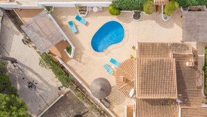 An aerial view of a resort with a swimming pool, sun loungers, a covered seating area, and a tiled roof. - Carlota by Interhome (Moraira)