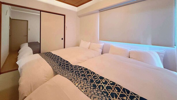 Una habitación de hotel con una cama grande, techo de madera y una ventana con persianas.