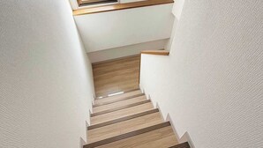 A narrow staircase with wooden steps and a skylight at the top. - Stylish 2-Story Apartment Near Atomic Bomb Dome (Hiroshima)