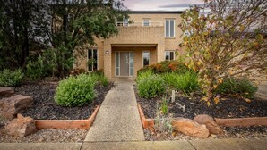 A modern two-story house with a brick exterior, a front door, and a pathway leading to the entrance. - Daintree Family Getaway- Beach, Aircon, Great yard (Ocean Grove)