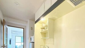 A modern kitchen with a stainless steel stove, white cabinets, and a wooden floor.