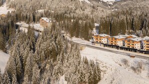 A hotel with multiple buildings surrounded by snow-covered trees and mountains. - Studio für 2 Personen by Interhome (Mittersill)