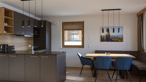A modern kitchen with dark cabinets, a central island, and pendant lighting.