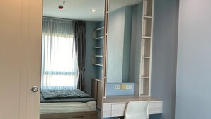 Une chambre à coucher comprenant un lit, un bureau, une chaise et une armoire.