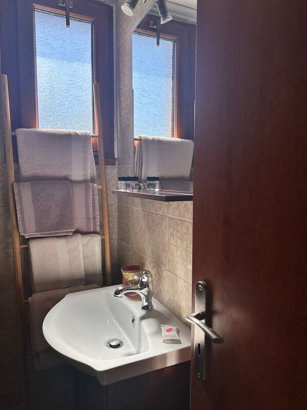Une salle de bain équipée d’un lavabo, d’un porte-serviettes et d’un miroir.