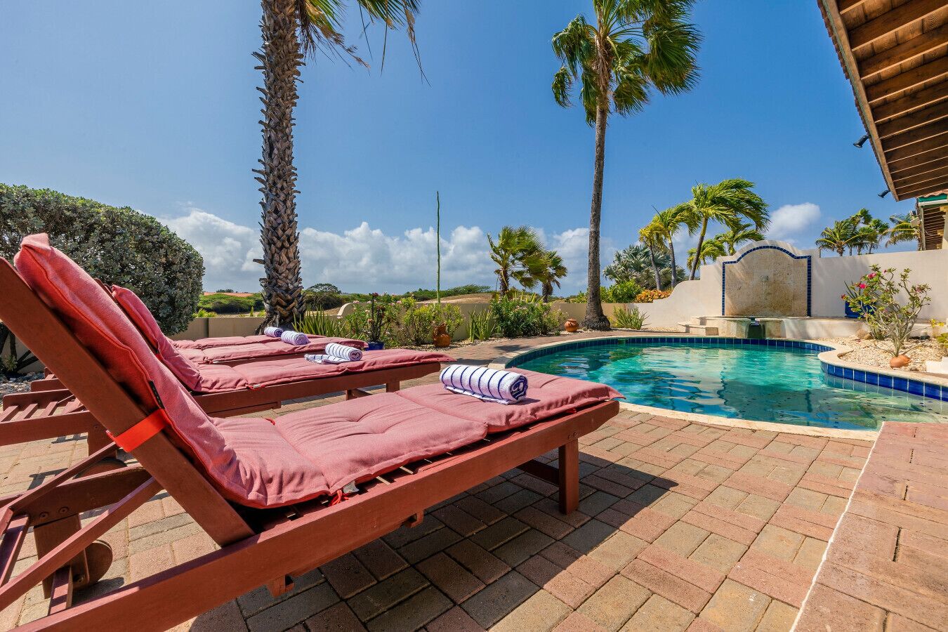 A poolside area with lounge chairs and a pool.