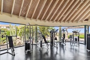An outdoor gym with various exercise equipment, a covered area, and a view of the surrounding landscape.