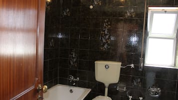 Un baño con bañera, inodoro y lavamanos.