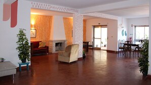Eine geräumige Lobby mit Kamin, Sitzgelegenheiten und einem Esstisch.