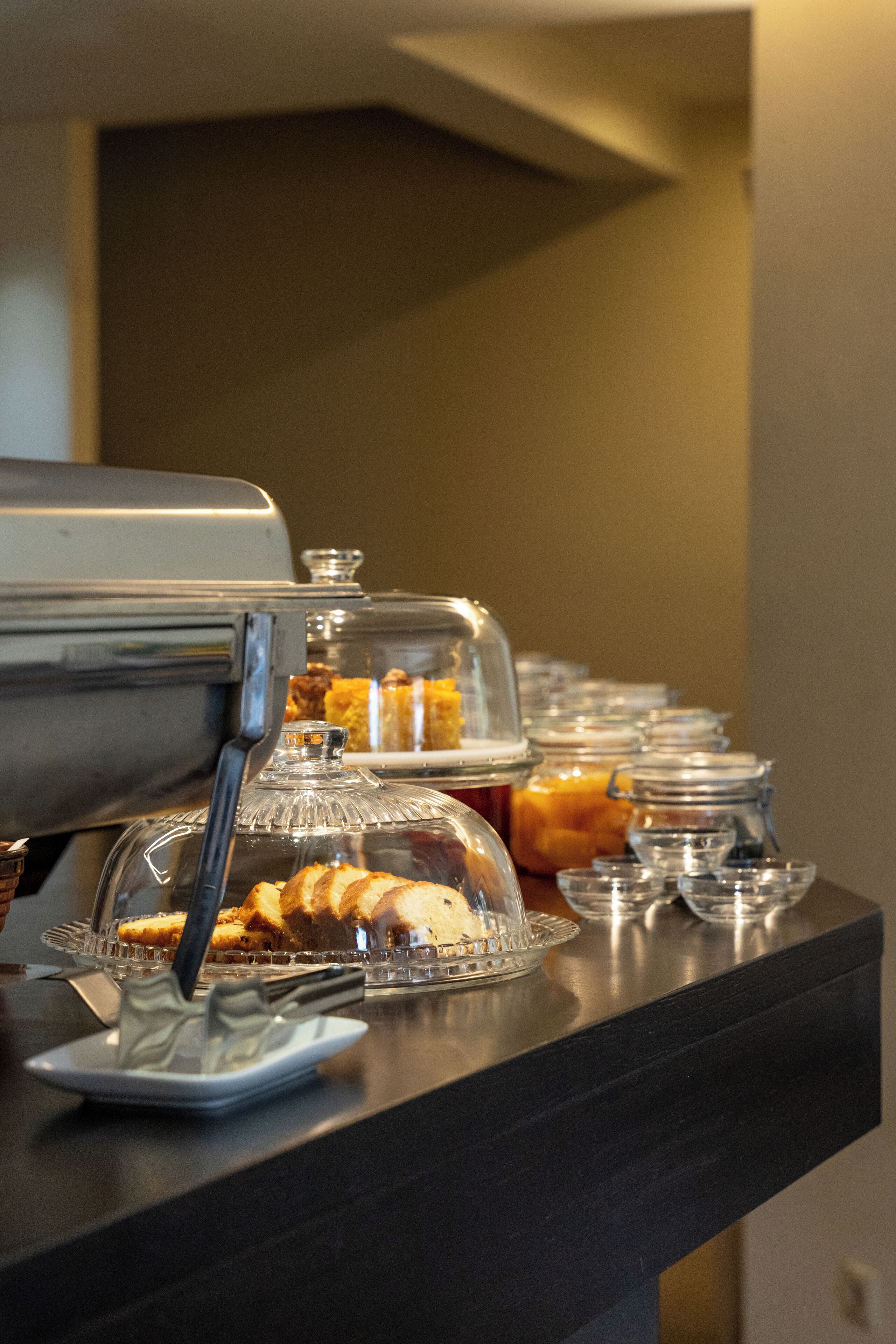A buffet counter with various food items and a coffee machine.