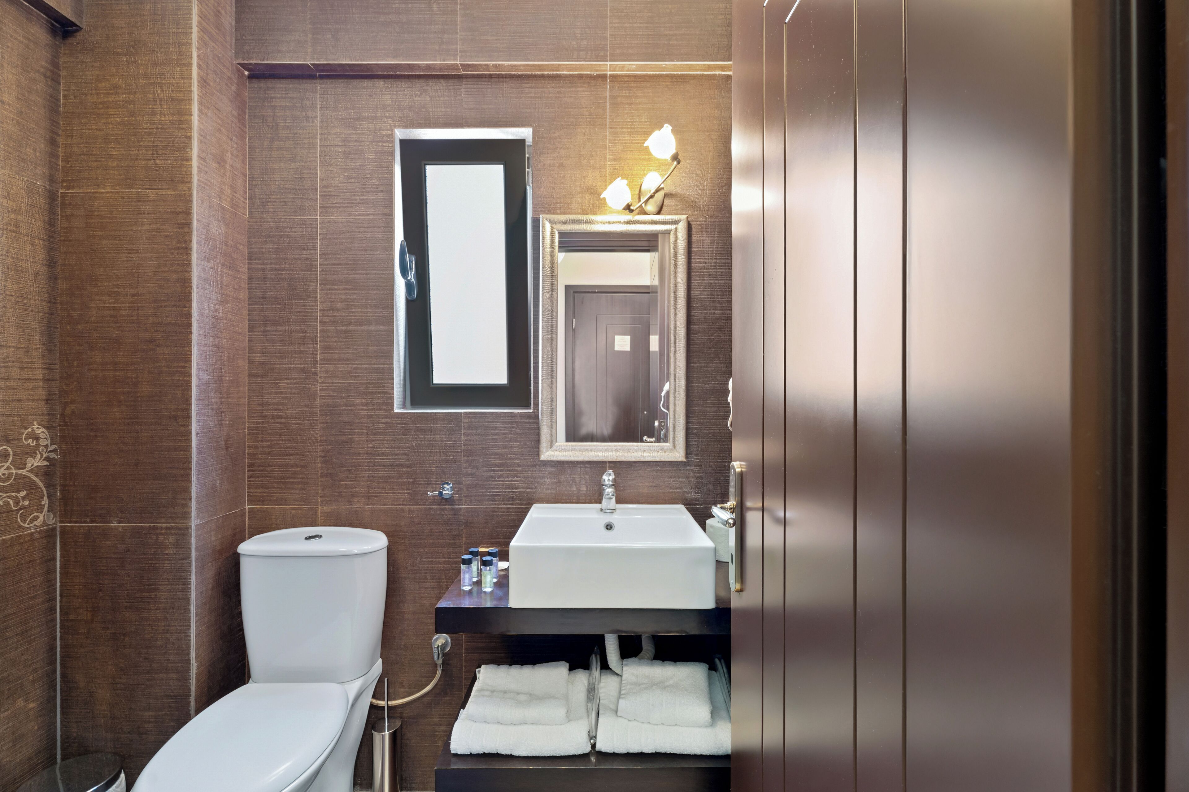 A modern bathroom with a toilet, sink, and towel rack.