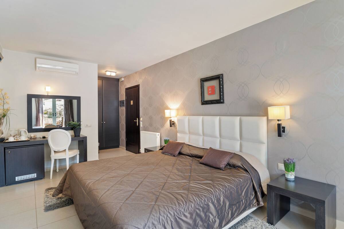 Un dormitorio moderno con una cama grande, mesitas de noche, un escritorio y una silla.