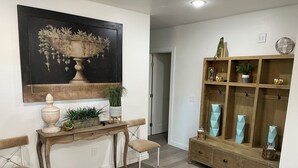 Ein Konsolentisch aus Holz mit einer Vase, einer Topfpflanze und einer kleinen Lampe.