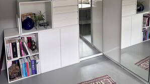 A room with a white wardrobe, a bookshelf, a mirror, and a patterned rug. - Spacious apartment for a family of 4 with easy access to metro, grocery, parks (København)