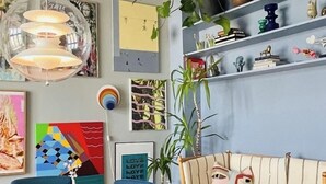 A modern living room with a round table, chairs, a sofa, a ceiling fan, and wall-mounted shelves with decorative items. - Spacious apartment for a family of 4 with easy access to metro, grocery, parks (København)