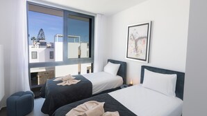 A hotel room with two beds, a large window, and a framed picture on the wall. - Protaras Aqua Pearl Villa Aq18 (Paralimni)