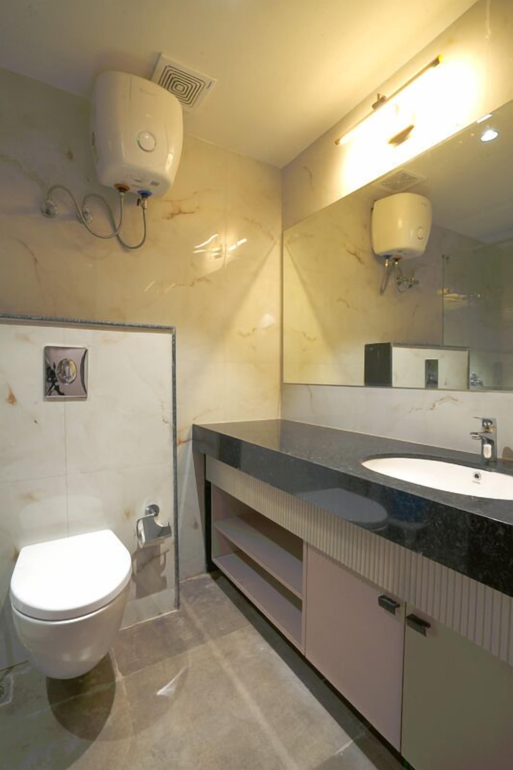 A modern bathroom with a white toilet, a sink, and a mirror.