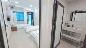 A hotel room with two beds, a bathroom with a large mirror, and a sliding door. - HT Airport Inn (Hanoi)