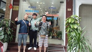 A hotel entrance with signs for services like motorbike rental, hotel & homestay, and training service. - HT Airport Inn (Hanoi)