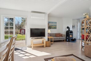 A living room with a TV, sofa, fireplace, and a bookshelf.