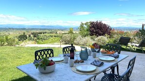 A table set outdoors with a scenic view, including a bowl of fruit, plates, and a pitcher. - Belmonte Spereto, Pool, Nature, View, Montaione (Montaione)