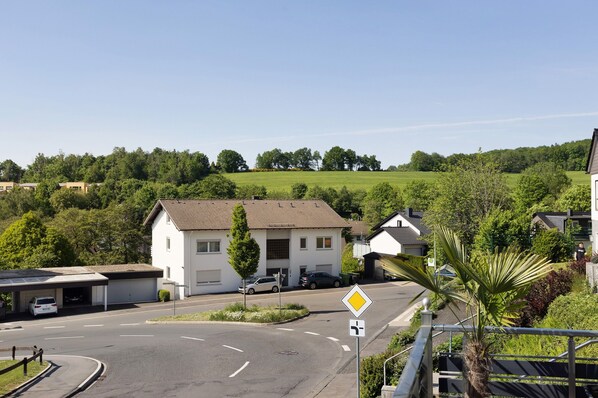 A residential area with a white house, a roundabout, and a clear sky.