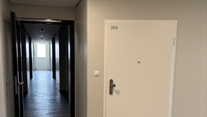 A hallway with a door labeled 304, a light fixture on the ceiling, and a wooden floor. - Apartment 'Dargies' with Sea View, Balcony and Wi-Fi (Cuxhaven)