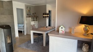 Una cocina moderna con comedor, chimenea y una lámpara en la encimera.