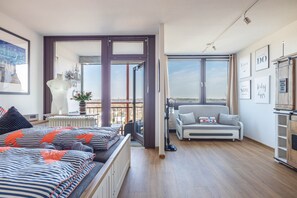 Une chambre moderne avec un lit, un canapé, une vue sur l’extérieur et une fenêtre.