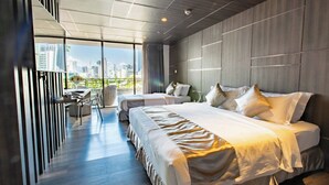 Una habitación de hotel moderna con dos camas, un escritorio y vista al horizonte de la ciudad.