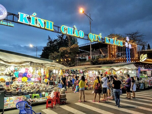 A bustling night market with various stalls selling hats and other items. - Brilliant Bay Nha Trang Hotel (Nha Trang)
