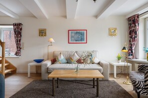 A living room with a sofa, a coffee table, a lamp, and a picture frame on the wall.