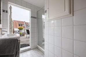 Une salle de bain avec une douche, un lavabo et un porte-serviettes.