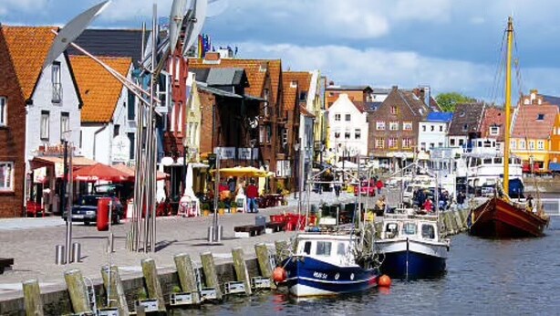 A harbor with boats docked, buildings with traditional architecture, and a clear sky. - Apartment 'Hafenambiente' with Private Terrace and Wi-Fi (Husum)