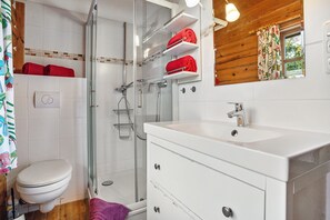 Un baño con inodoro, ducha y lavamanos.