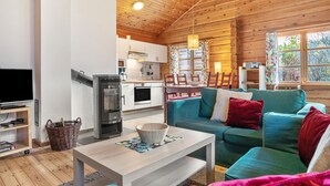 A cozy cabin interior with a wooden ceiling, a dining area, a sofa, a television, and a kitchen. - Apartment 'Johanna' with Private Terrace, Private Garden and Wi-Fi (Zislow)