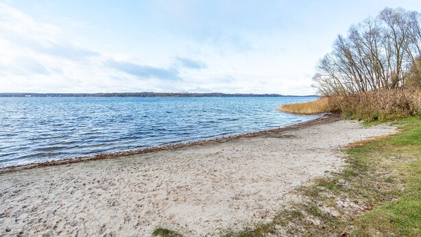 A beach with a sandy shore, a grassy area, and a body of water. - Apartment 'Johanna' with Private Terrace, Private Garden and Wi-Fi (Zislow)