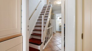 Eine Treppe führt zu einer Zwischenebene, im Hintergrund ist eine Küche zu sehen.