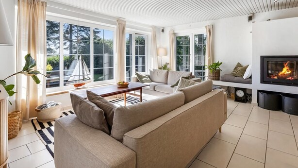 A modern living room with a sofa, a coffee table, and a fireplace.