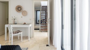 Et moderne interiør med spiseplads, trappe og et stort vindue.