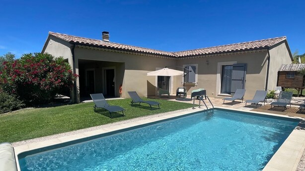 Ein Schwimmbecken mit Liegestühlen und einer Terrassenanlage.