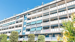 A multi-story hotel with balconies, a flag, and a clear blue sky. - Apartment in Caorle with balcony (Caorle (VE))