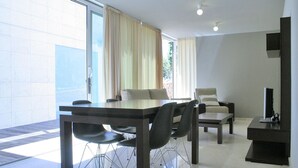 Un'area pranzo moderna con un tavolo e sedie, un divano e un mobile TV.