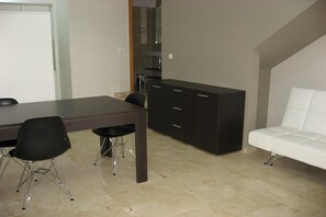 A modern kitchen with a dark wooden table, black chairs, and a white sofa. - House in La Escala near Els Riells Beach (L' Escala)