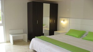 Un dormitorio con cama, armario, mesita de noche y banco.